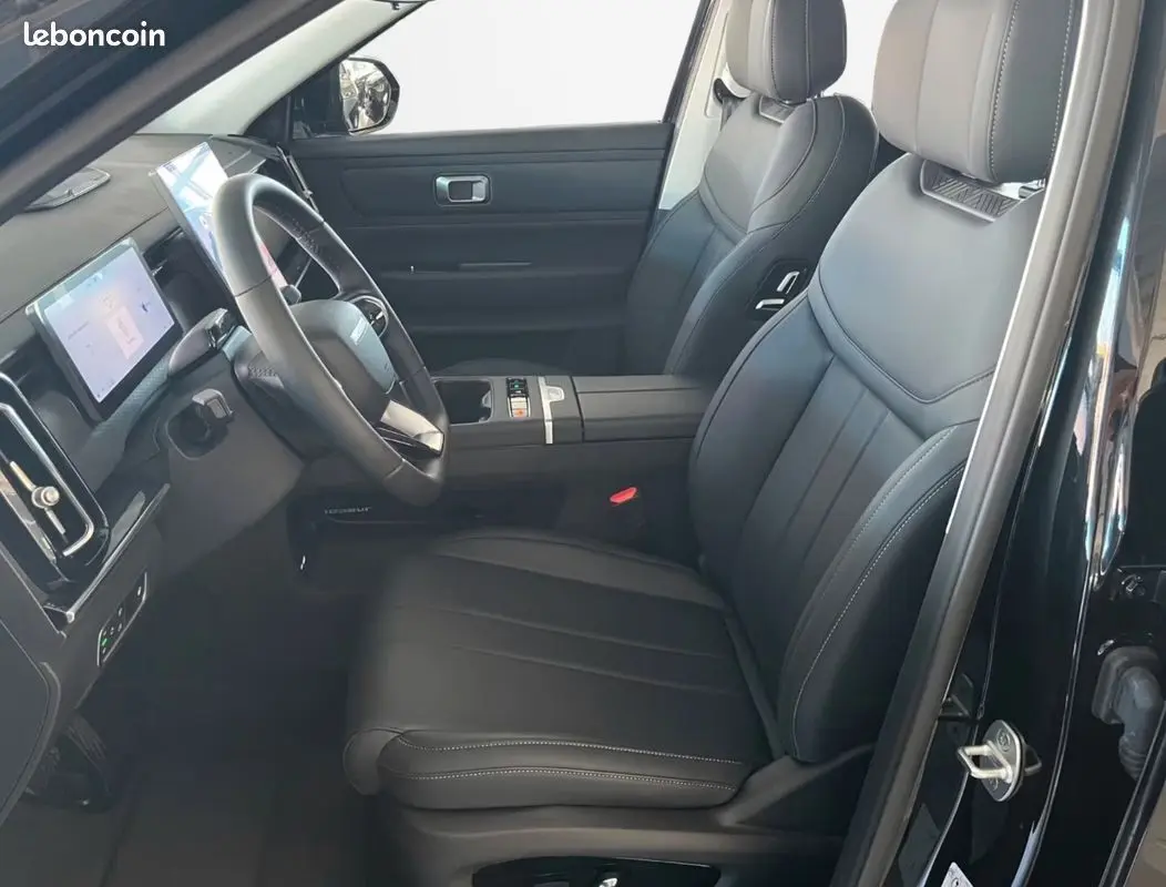 Intérieur avant côté conducteur du JAECOO J7 noir, montrant sièges cuir et tableau de bord avec écran tactile.