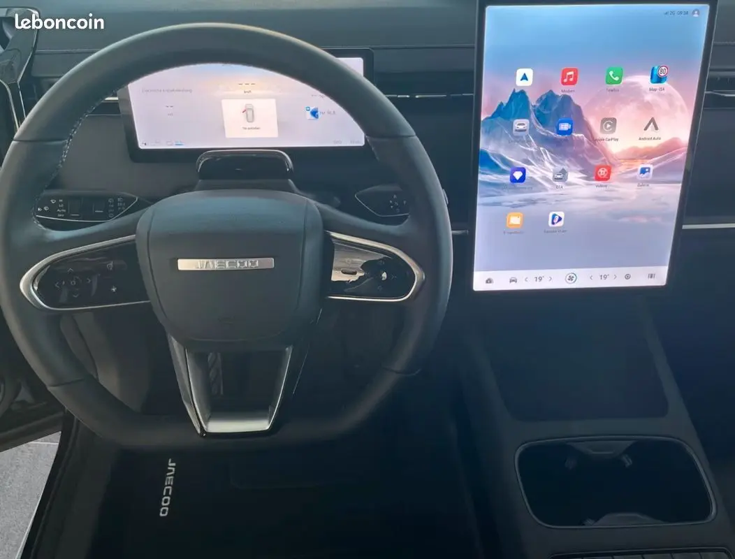 Vue intérieure frontale du volant noir JAECOO J7 1.5 TGDI 279ch avec grand écran tactile vertical lumineux.