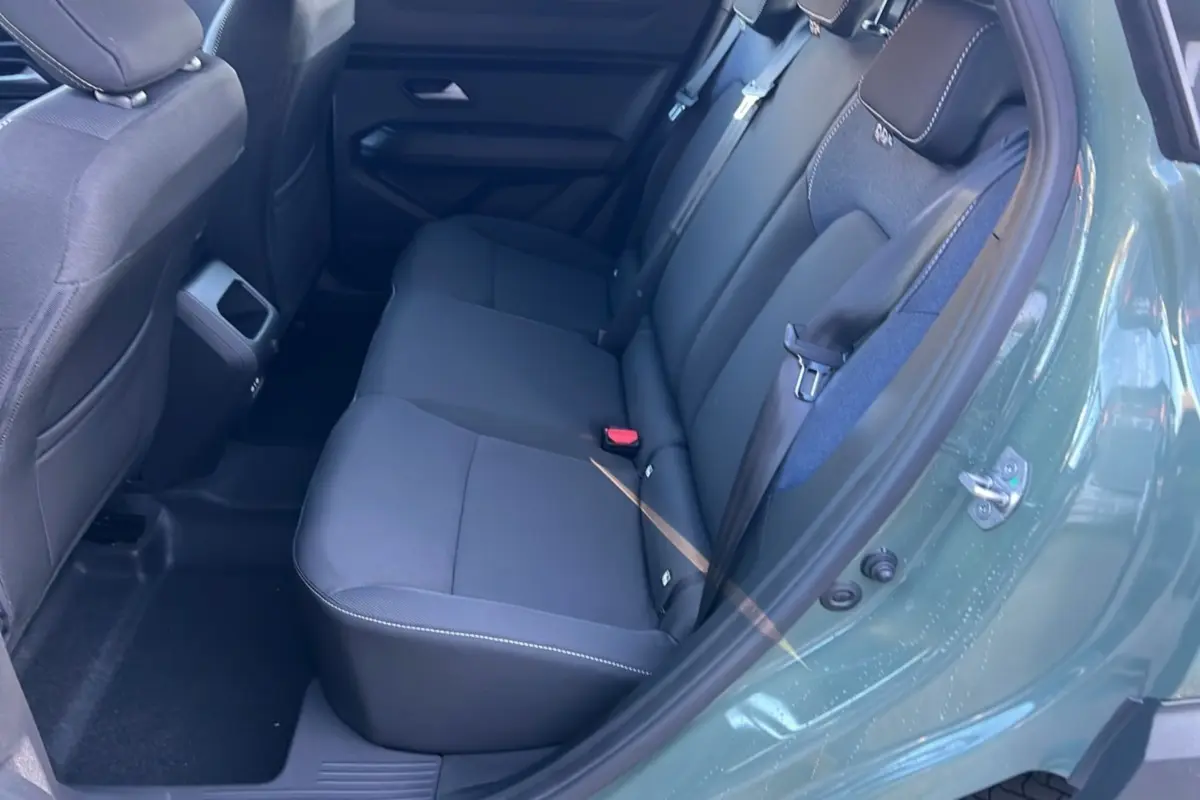 Vue intérieure côté gauche des sièges arrière noirs du Dacia Duster 2025 en kaki lichen, version Mild Hybrid 130 4x4 Expression.