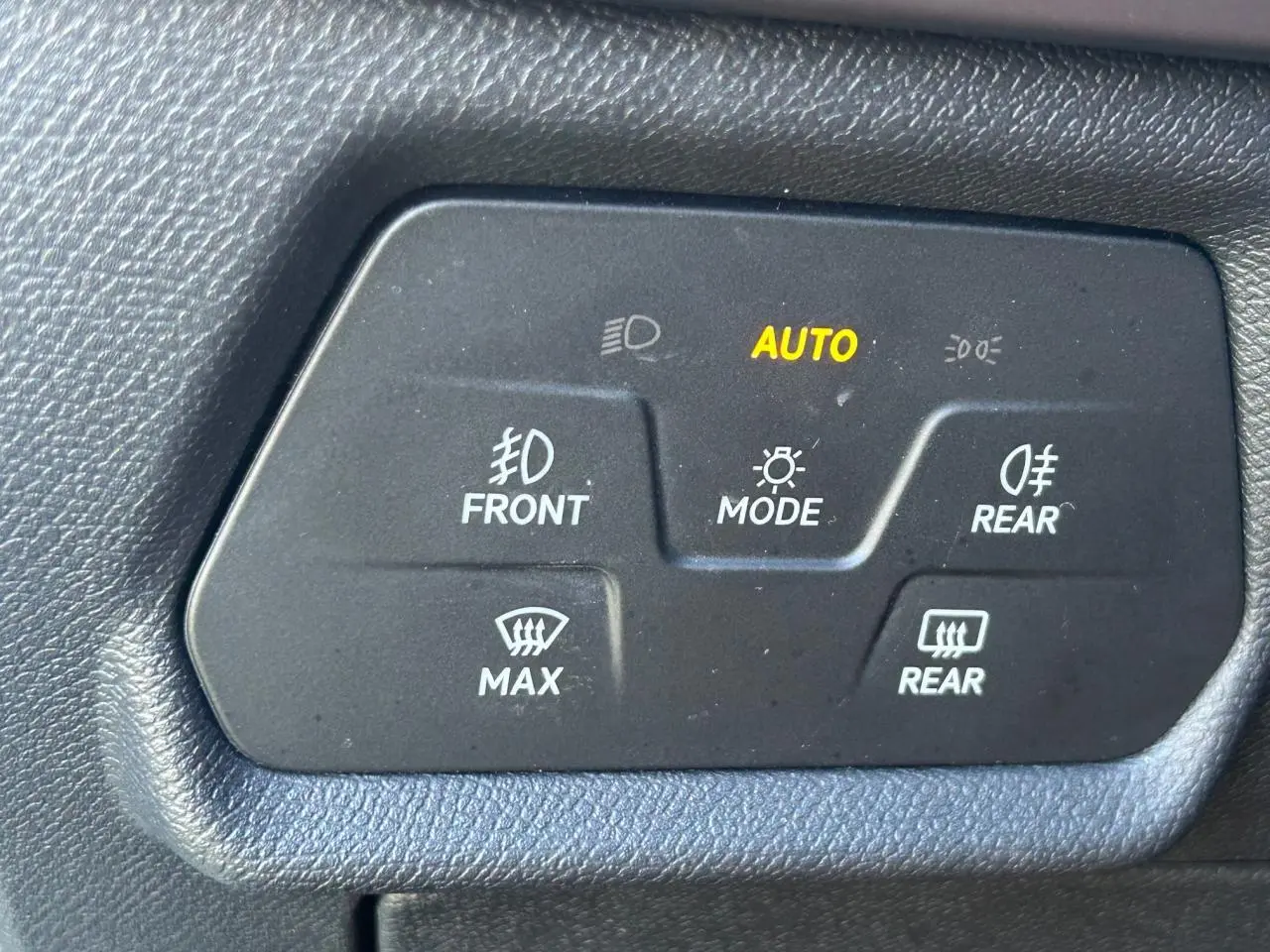 Gros plan sur les commandes d’éclairage intérieures noires du CUPRA Formentor blanc neige, avec indication AUTO allumée.