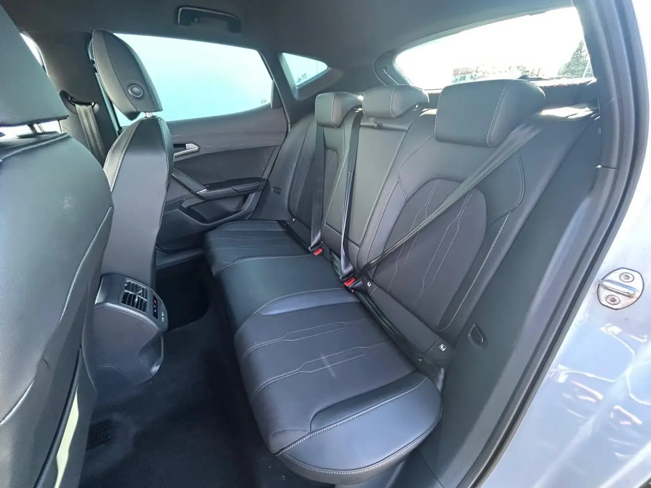 Vue intérieure côté droit sur la banquette arrière en cuir noir du CUPRA Formentor blanc neige 2025.