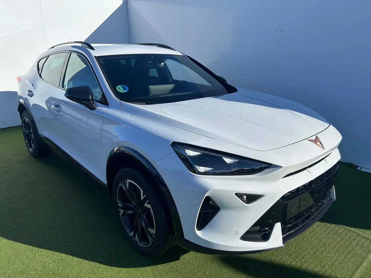 Vue 3/4 avant droite du CUPRA Formentor blanc neige avec jantes alliage 18'' et coques de rétroviseurs noires.