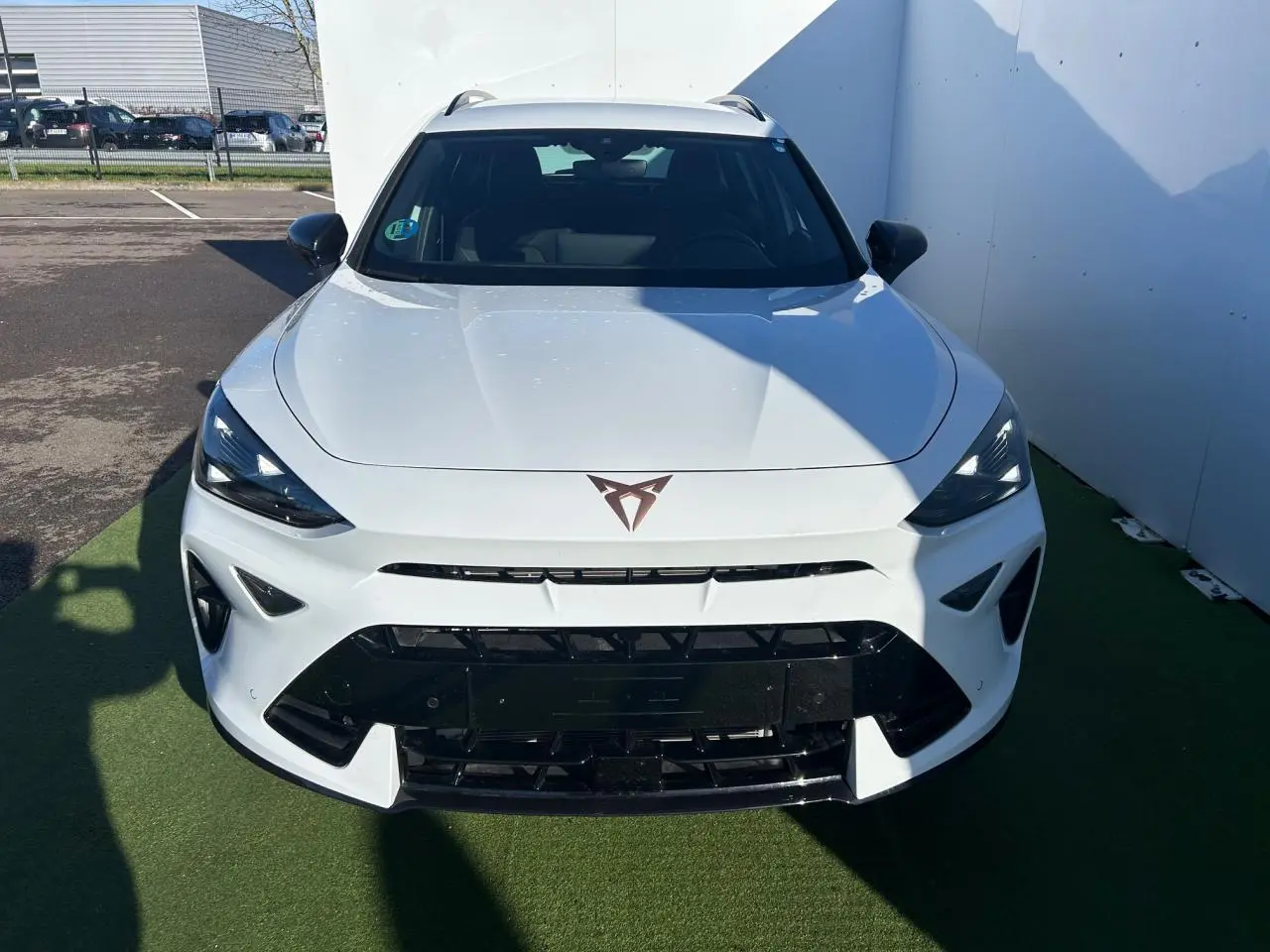 Vue avant d'un CUPRA Formentor blanc neige avec logo CUPRA et calandre noire contrastante sur fond extérieur.