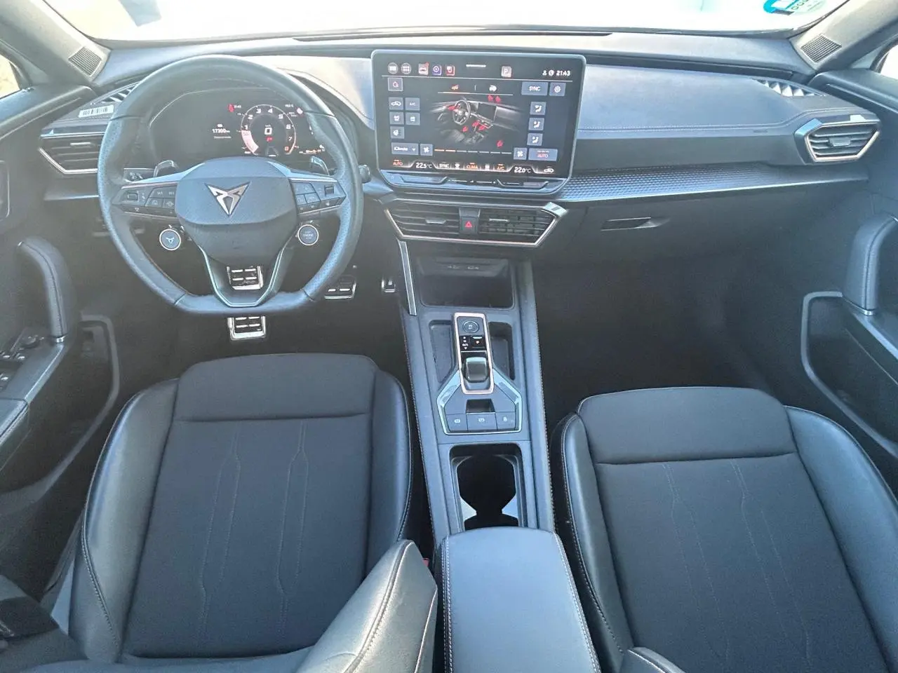 Vue intérieure avant du CUPRA Formentor blanc neige 2025, avec tableau de bord digital et volant multifonction cuir noir.