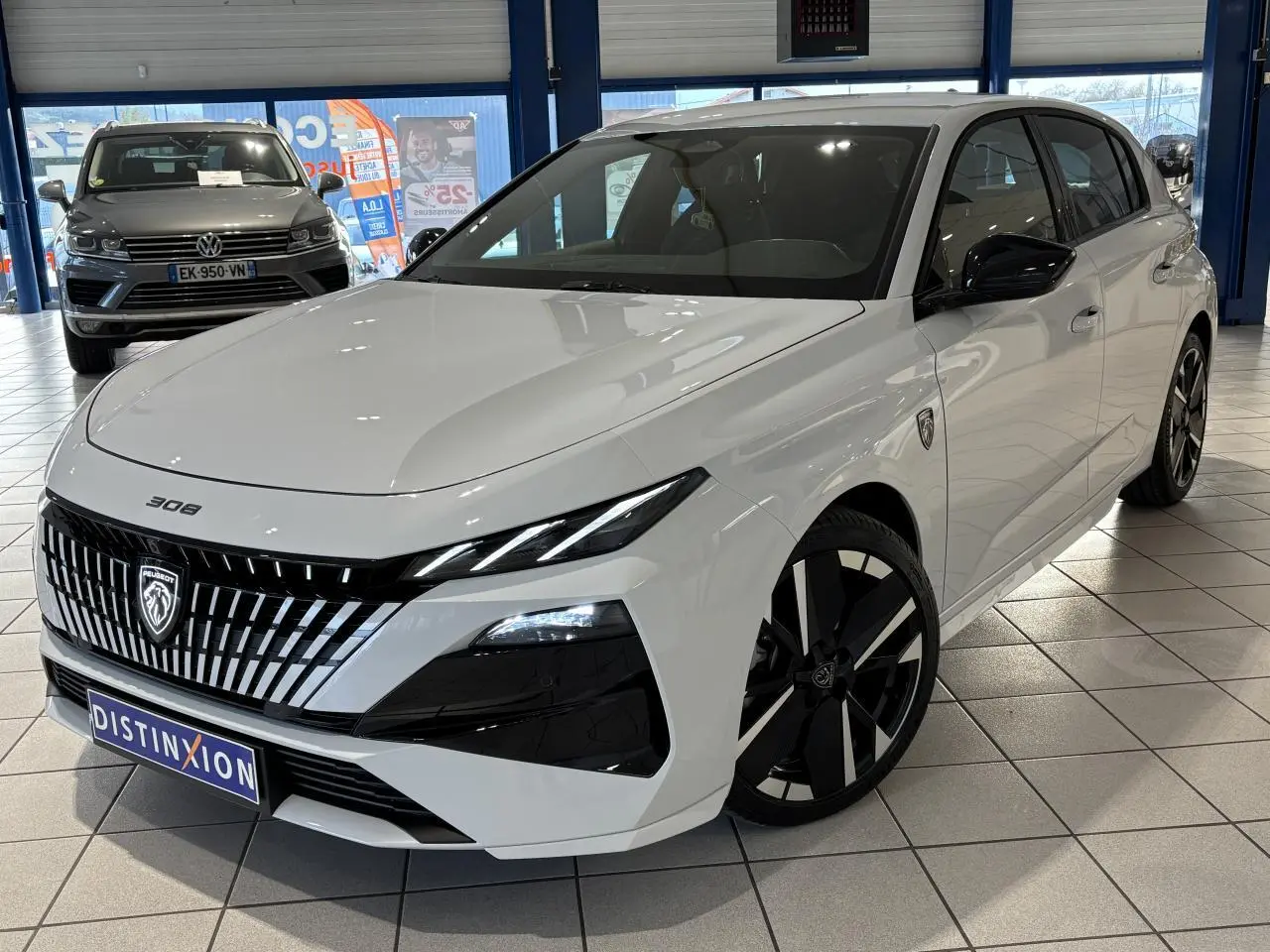 Peugeot 308 Hybrid blanc Okenite vue 3/4 avant droit avec calandre noire et jantes bi-tons en showroom.