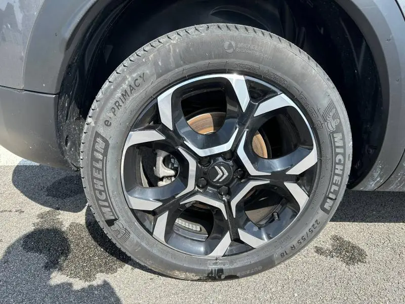 Gros plan sur la roue avant gauche du Citroën C5 Aircross gris Platinium avec jante alliage noire et argentée.