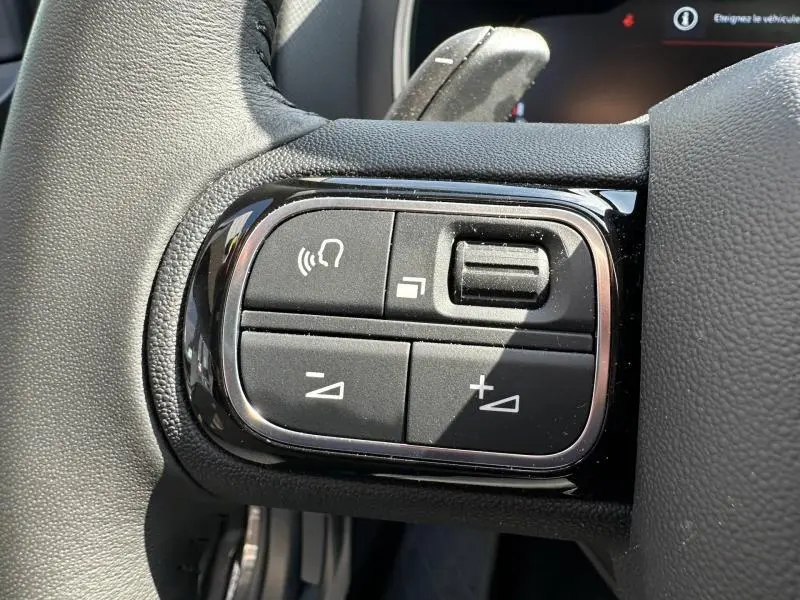 Gros plan sur les commandes vocales et volume au volant du Citroën C5 Aircross 2025 en gris Platinium.