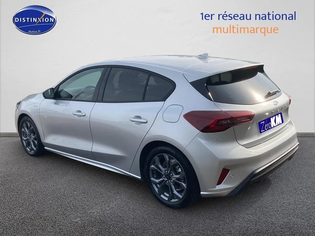 Vue 3/4 arrière droite d'une Ford Focus gris clair avec jantes alu 17 pouces et vitres arrière surteintées.