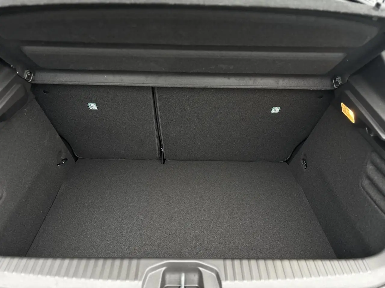 Coffre ouvert noir de la Renault Clio V NV E-Tech Full Hybrid 145 Esprit Alpine, vue intérieure arrière.