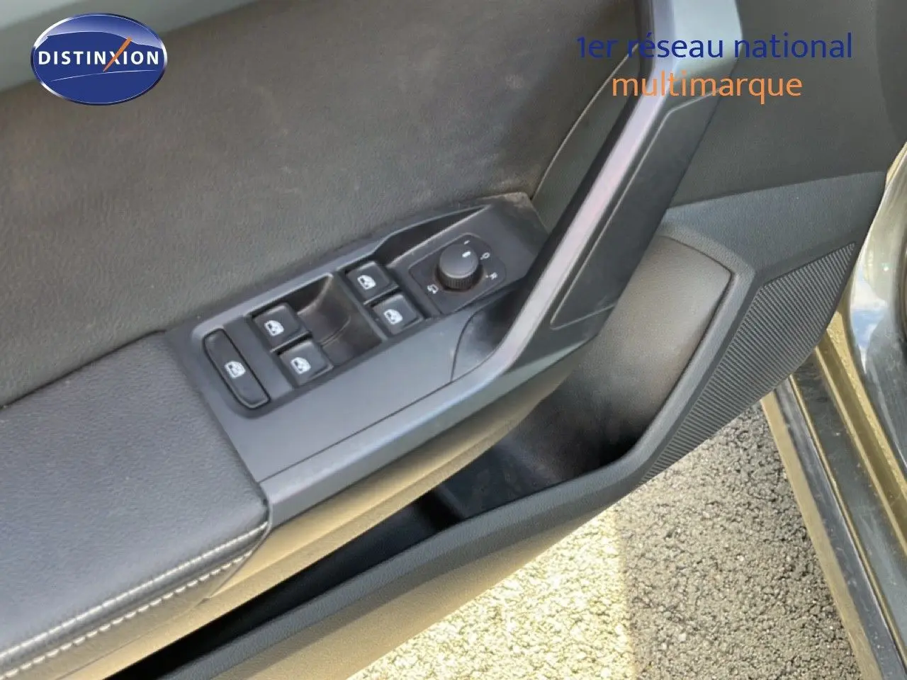 Détail des commandes de lève-vitres et rétroviseurs sur la portière côté gauche d’un SEAT Arona gris falaise métal.