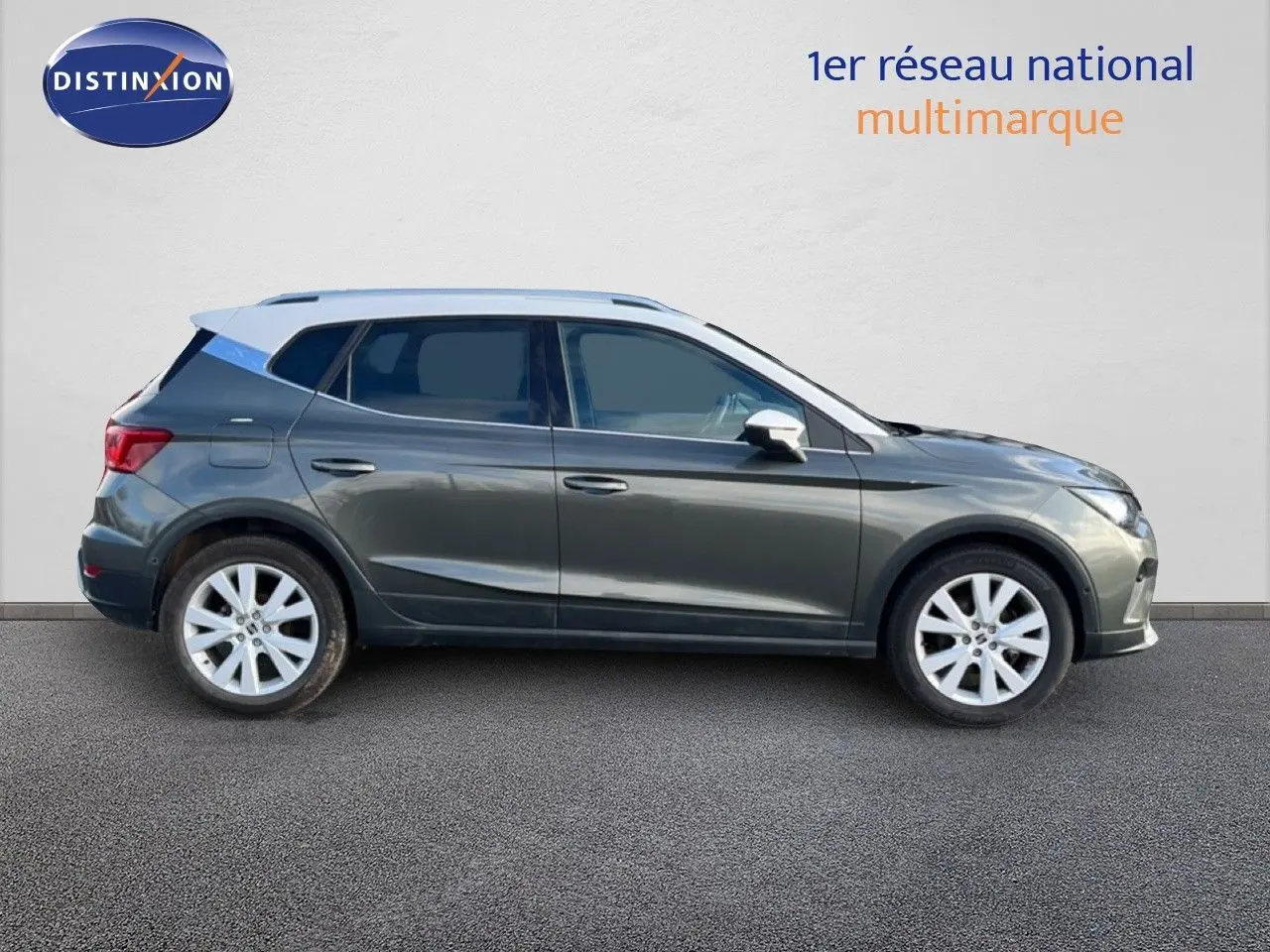 Vue de profil côté gauche d’un SEAT Arona gris falaise métallisé avec toit blanc, roues alliage et cinq portes visibles.
