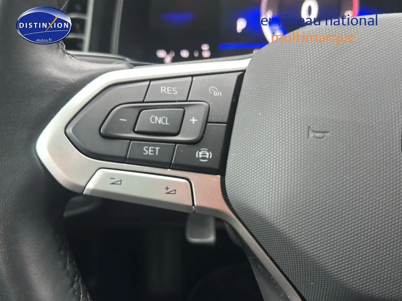 Gros plan sur les commandes au volant en cuir de la Volkswagen Polo noire, avec boutons de régulateur de vitesse.