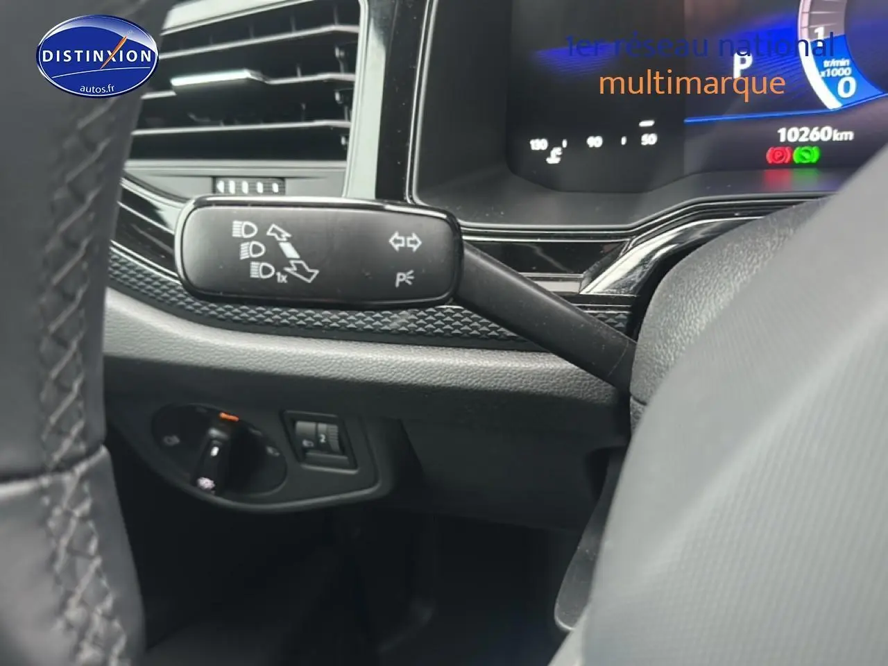 Détail intérieur du commodo gauche et tableau de bord numérique d'une Volkswagen Polo noire intense nacre 2025.