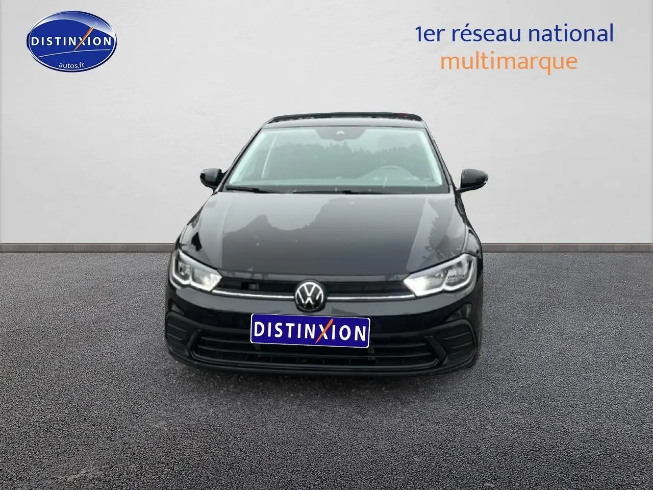 Vue frontale d'une Volkswagen Polo noire intense nacrée 2025 avec calandre épurée et phares LED allumés.