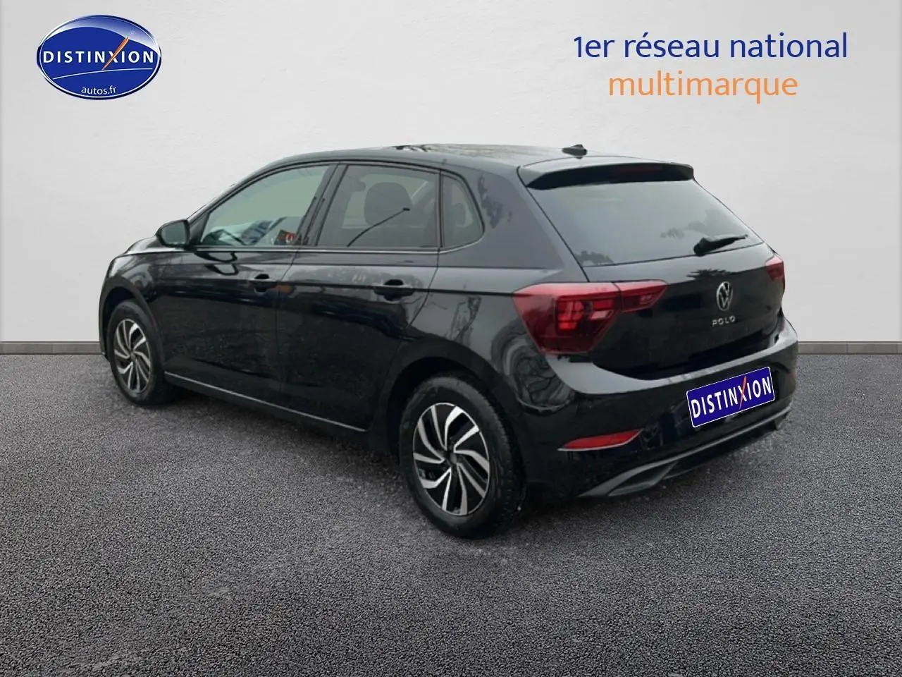 Volkswagen Polo noir intense nacré vue 3/4 arrière côté gauche sur sol gris devant mur blanc.