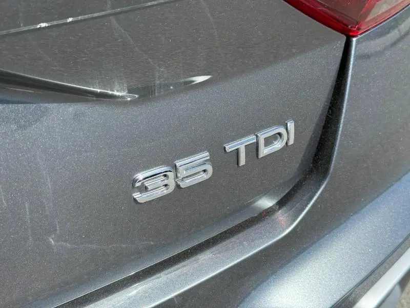 Gros plan sur l'arrière droit d'un Audi Q2 35 TDI gris Daytona nacré avec le badge moteur visible sous le feu arrière.