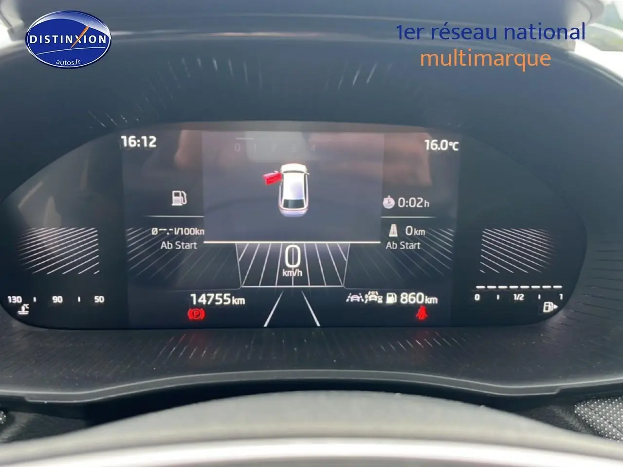 Tableau de bord numérique de la Skoda Fabia blanche, affichant la vitesse à 0 km/h et porte avant ouverte.