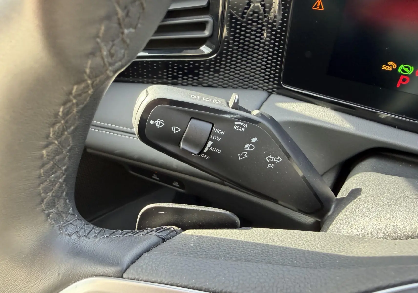 Gros plan sur la manette des essuie-glaces à gauche du volant dans l'habitacle gris du Volkswagen Tiguan 2025.