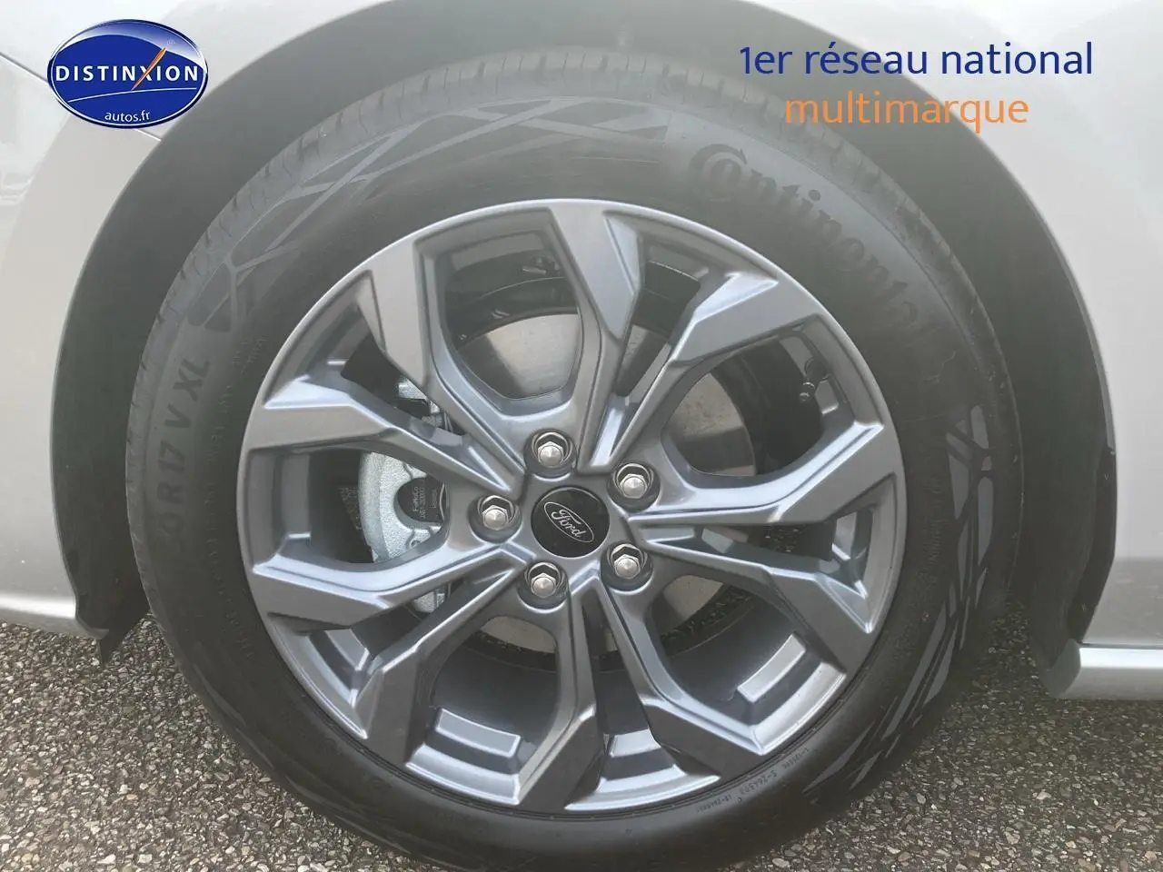 Gros plan sur la jante alu 17 pouces gris foncé d'une Ford Focus gris clair 2025 côté gauche.