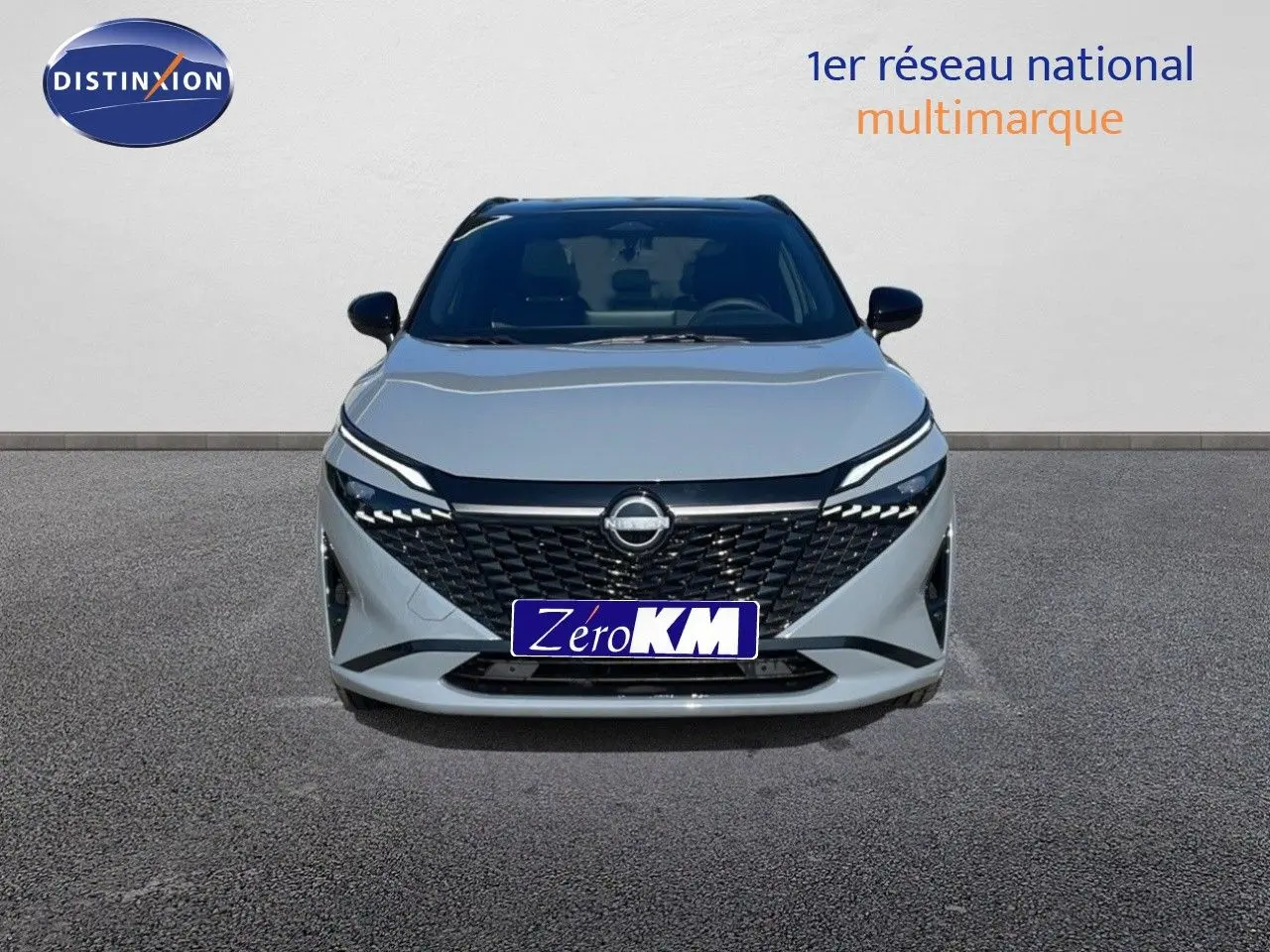 Vue frontale d'un Nissan Qashqai 2025 gris céramique avec toit noir, calandre noire et phares LED distinctifs.