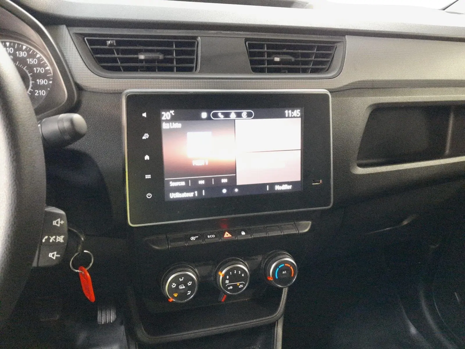 Vue rapprochée du tableau de bord noir du Renault Express Van 2023 avec écran tactile et commandes manuelles de climatisation.