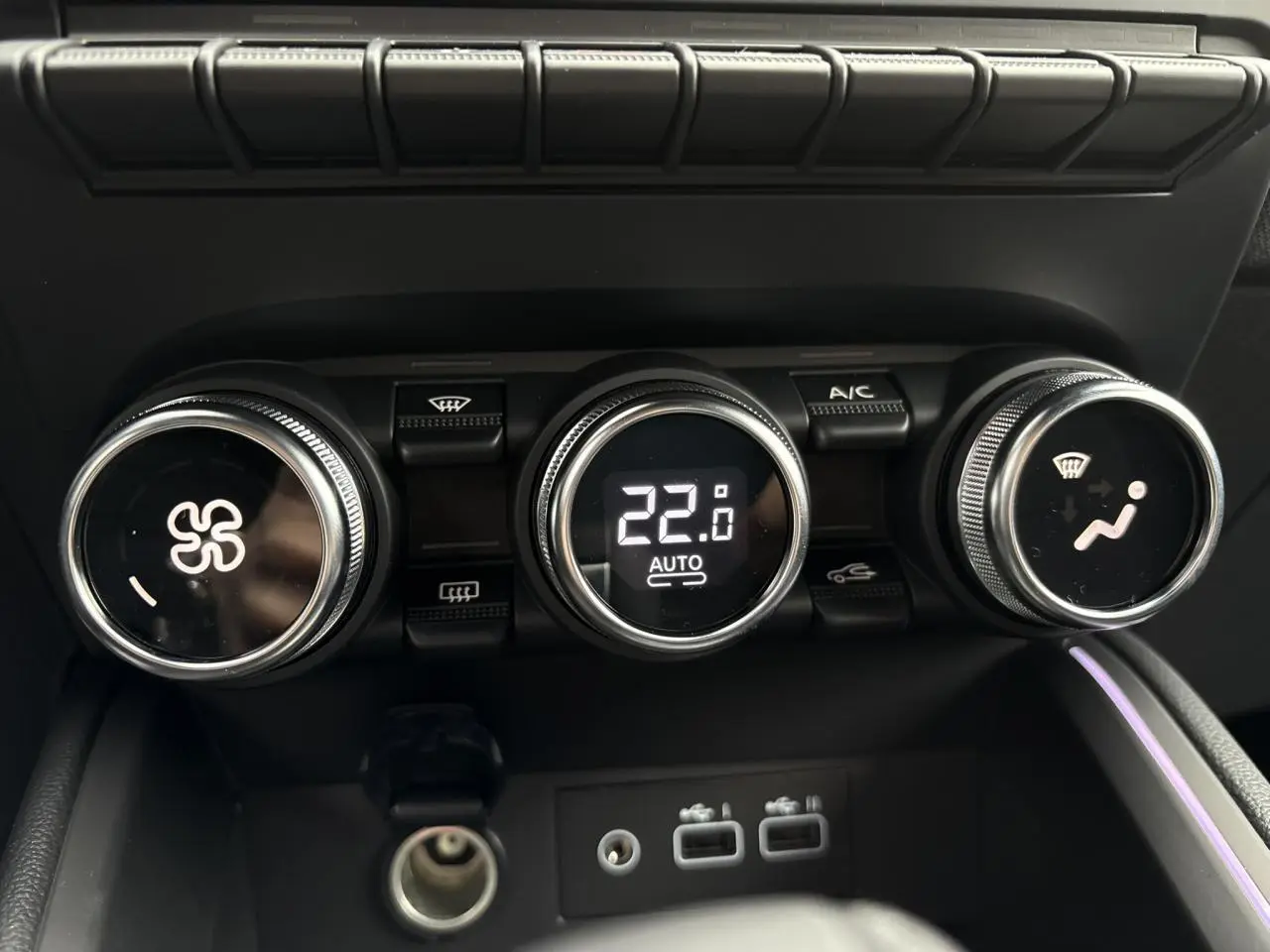Commandes de climatisation avec affichage digital à 22°C et éclairage d'ambiance violet dans la Renault Clio Gris Rafale.