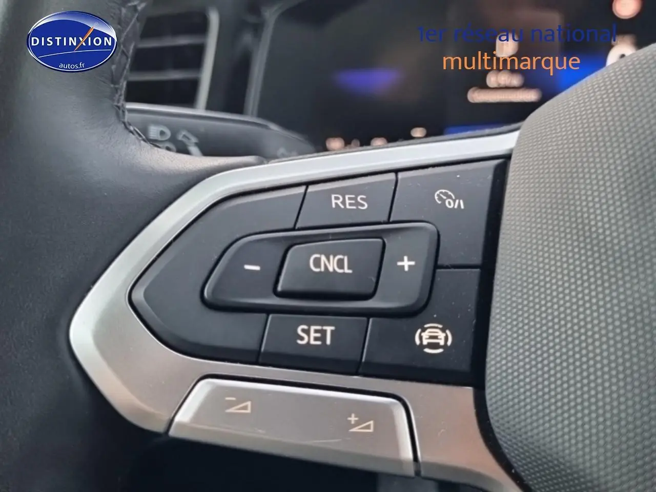 Gros plan sur les commandes de régulateur de vitesse au volant cuir d'une Volkswagen Polo noir intense nacré.