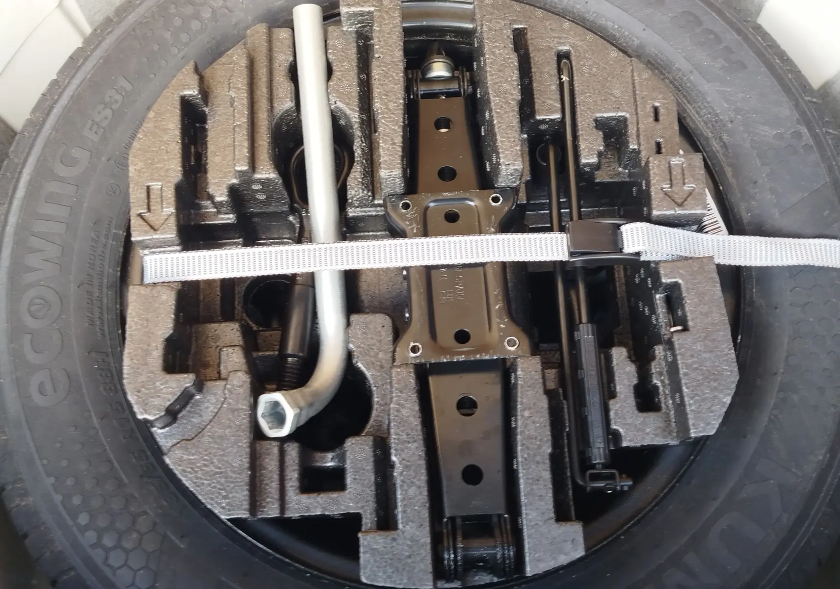 Gros plan sur la roue de secours et son kit d’outils de bord dans une Skoda Fabia Blanc Lune 2022.