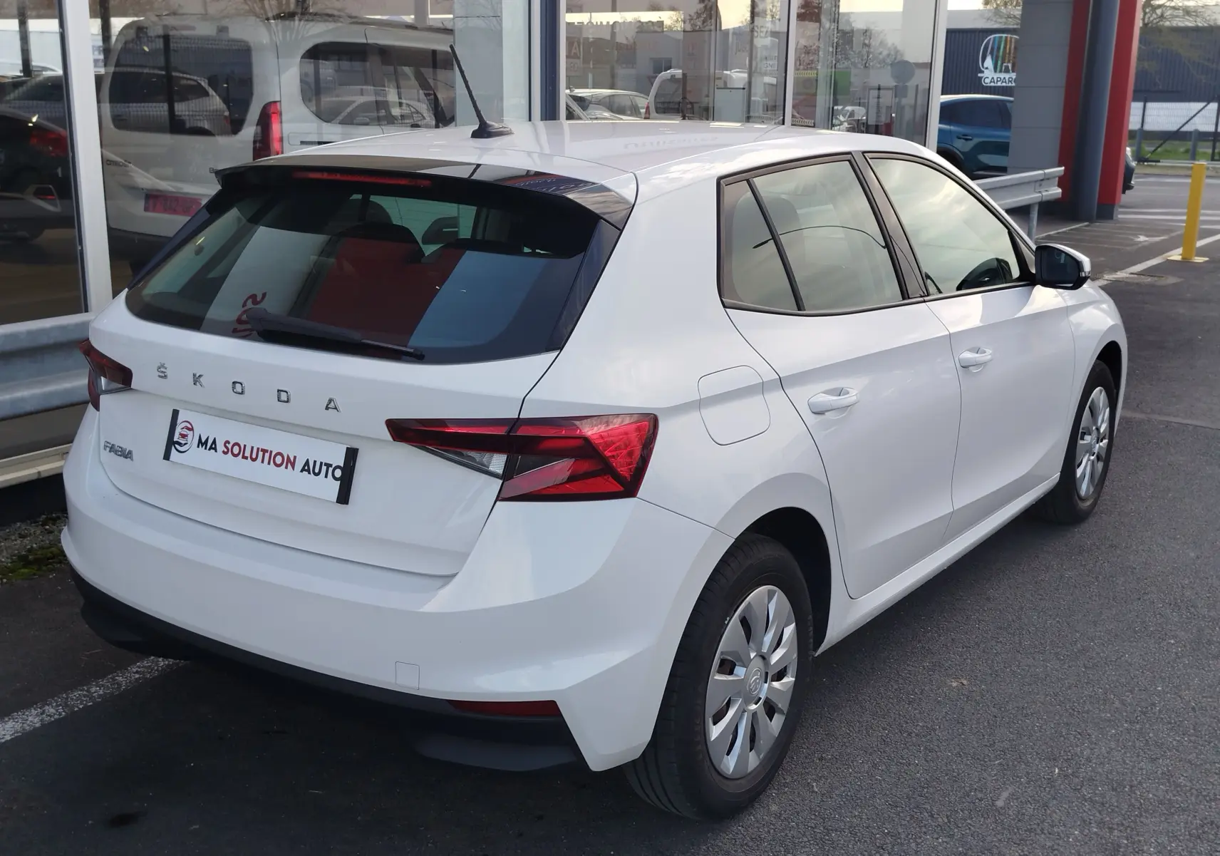 Vue 3/4 arrière droite d'une Skoda Fabia blanche Lune 2022 avec feux arrière LED et jantes acier.