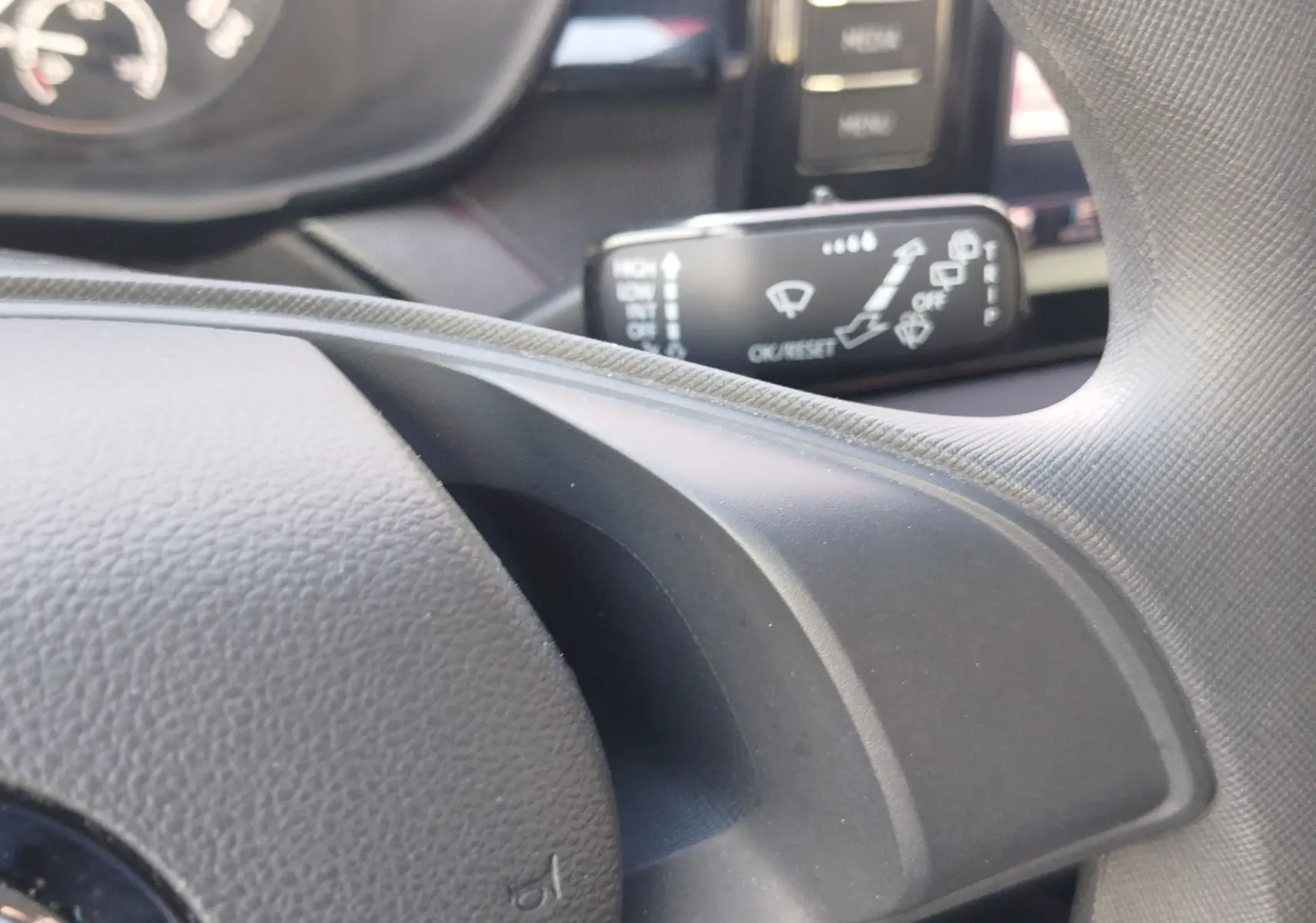 Gros plan sur la manette de commande des essuie-glaces côté droit du volant d’une Skoda Fabia blanche 2022.