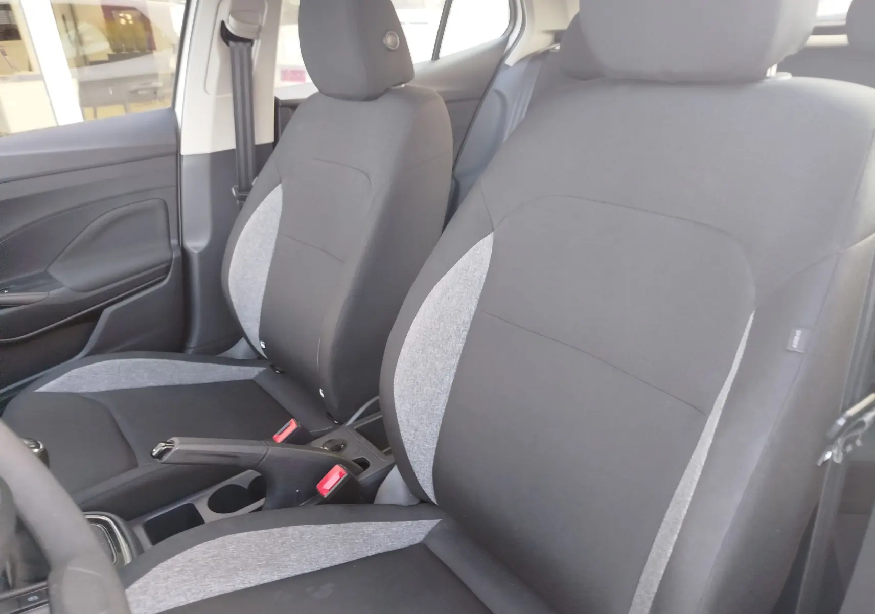 Vue intérieure des sièges avant en tissu gris et noir de la Skoda Fabia 1.0 MPI 80ch Active 2022, côté conducteur et passager.