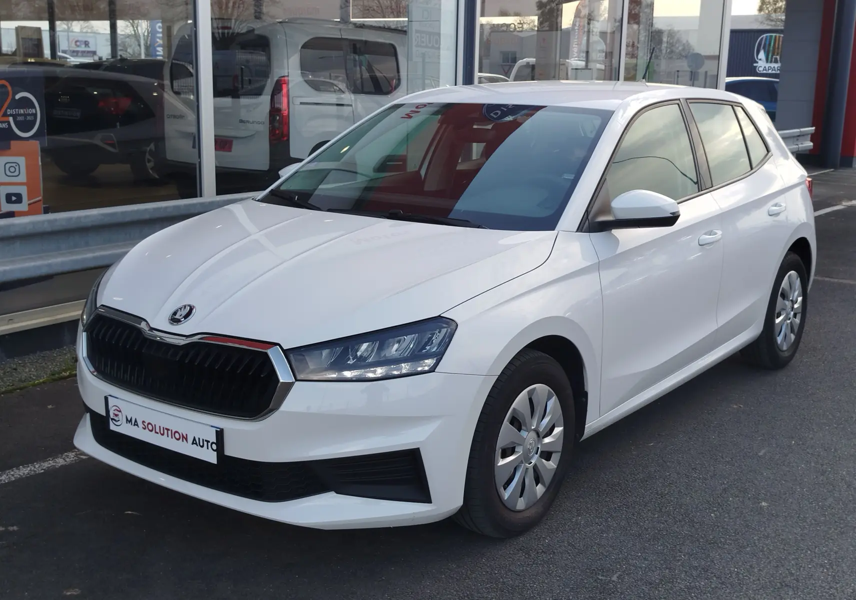 Vue 3/4 avant droite d'une Skoda Fabia blanche Lune, avec calandre noire et jantes acier à enjoliveurs.