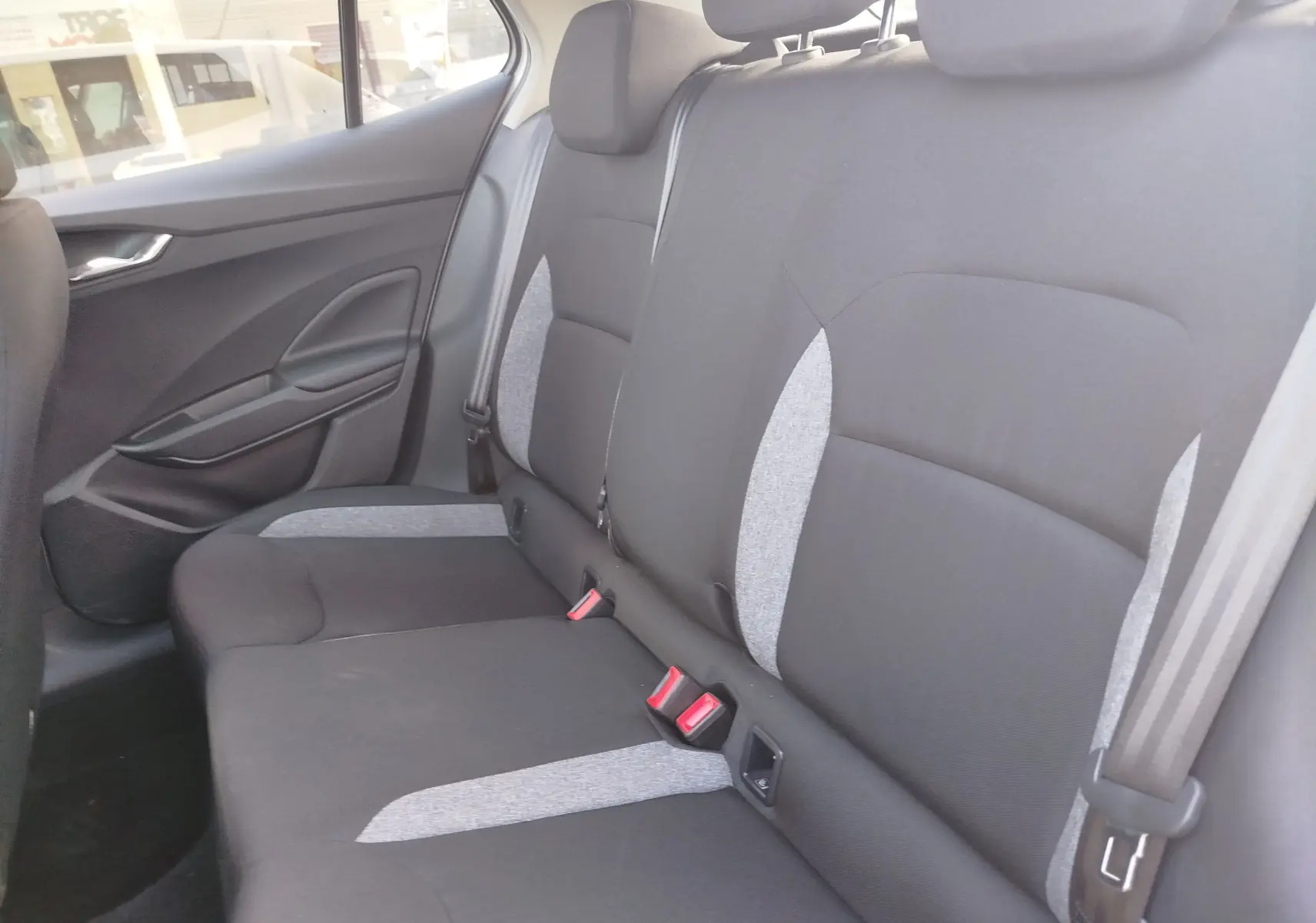 Vue intérieure du siège arrière côté gauche de la Skoda Fabia 2022 avec sellerie tissu noir et gris.