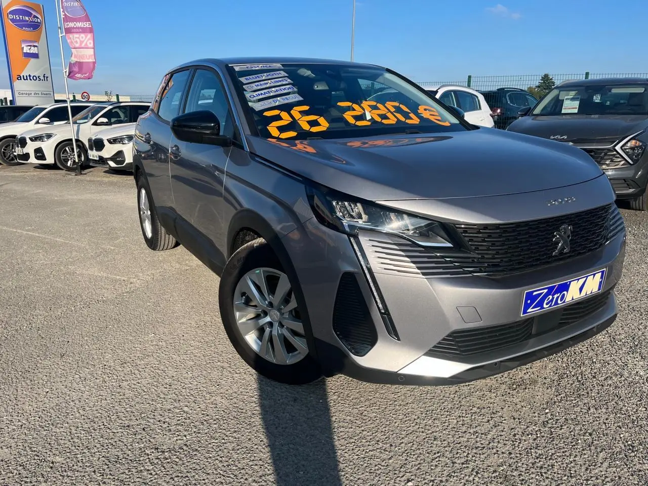 Peugeot 3008 gris Artense vue 3/4 avant droit sur parking avec prix affiché sur pare-brise.
