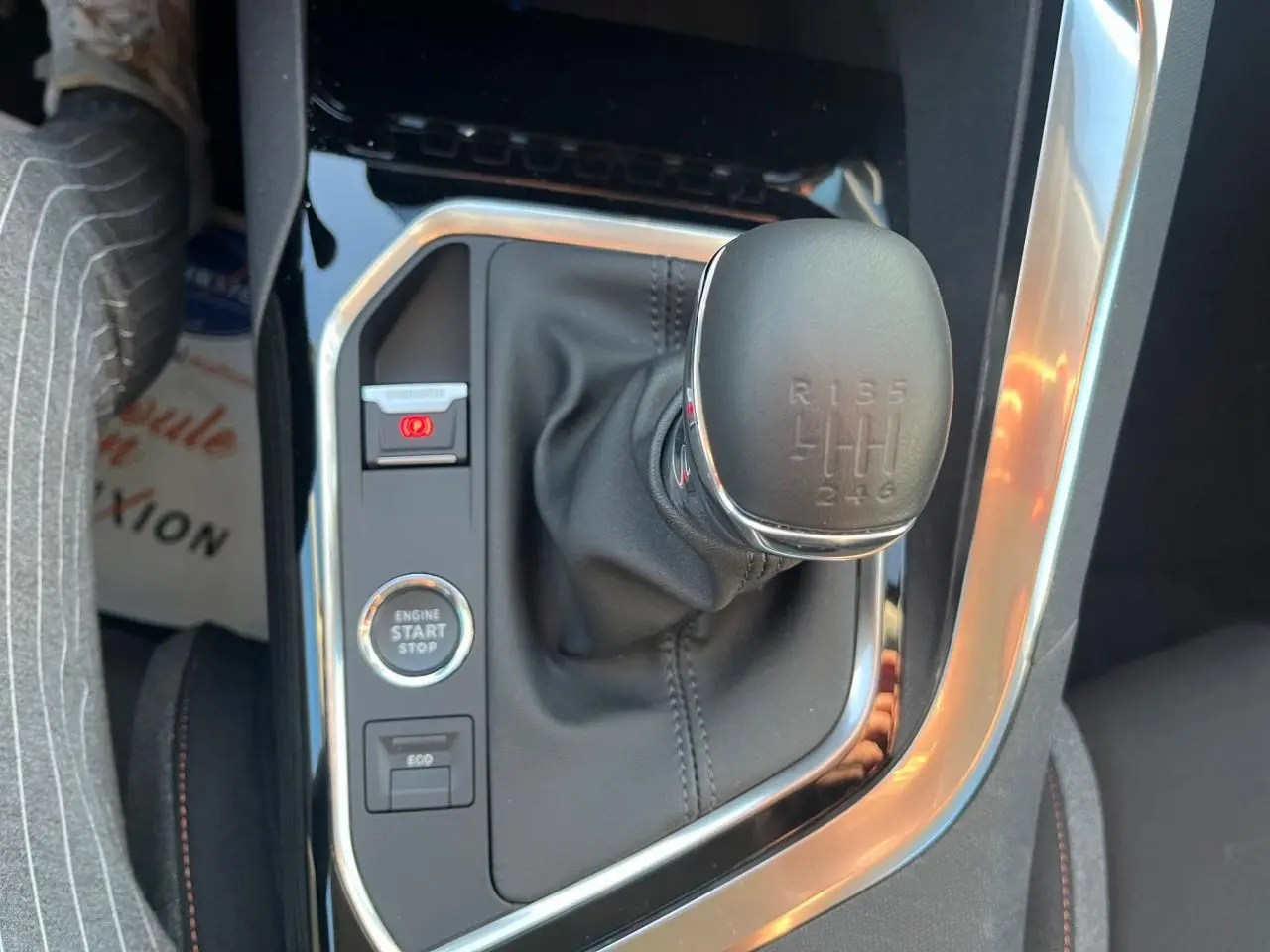 Gros plan sur le levier de vitesses manuel et les boutons de commande du Peugeot 3008 gris Artense, intérieur noir.