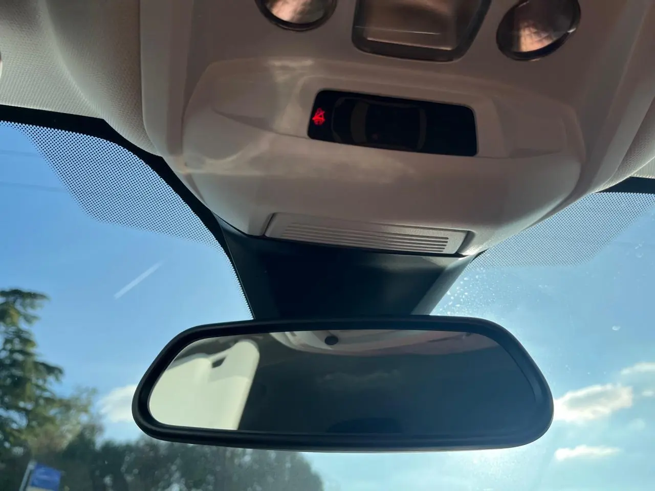 Rétroviseur intérieur d’un Peugeot 3008 gris Artense 2023, avec capteurs et ciel bleu en arrière-plan.
