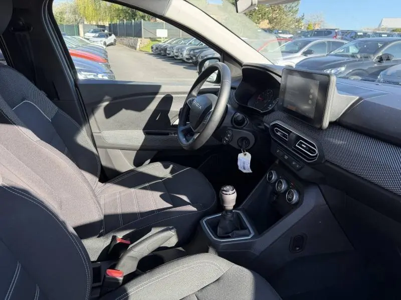 Vue intérieure côté conducteur du Dacia Jogger 2025, montrant le volant, la boîte manuelle et l’écran tactile sur tableau de bord.