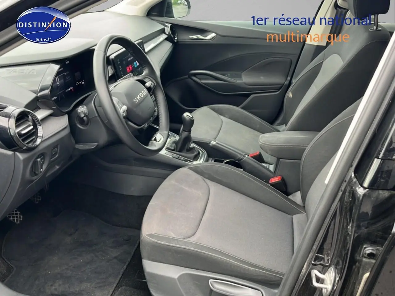 Intérieur avant noir de la Skoda Fabia 2025, vue côté conducteur avec volant cuir et console centrale manuelle.