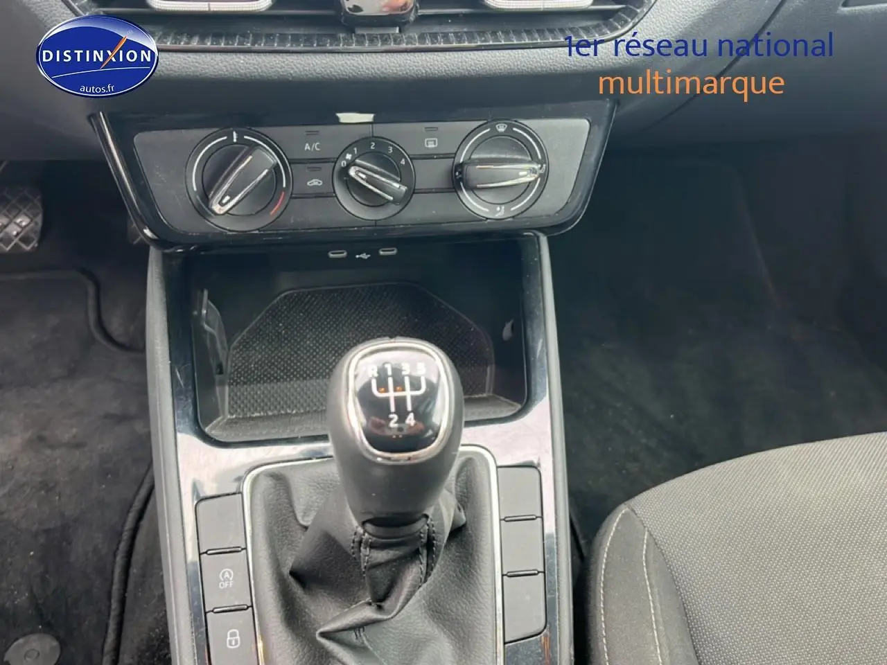 Gros plan sur le levier de vitesses manuel noir et la console centrale d’une Skoda Fabia noire, intérieur tissu gris.