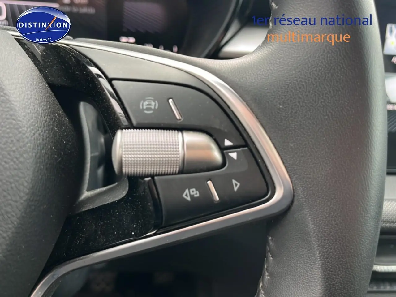 Gros plan sur les commandes multifonctions en aluminium et cuir du volant côté gauche d'une Skoda Fabia noire 2025.