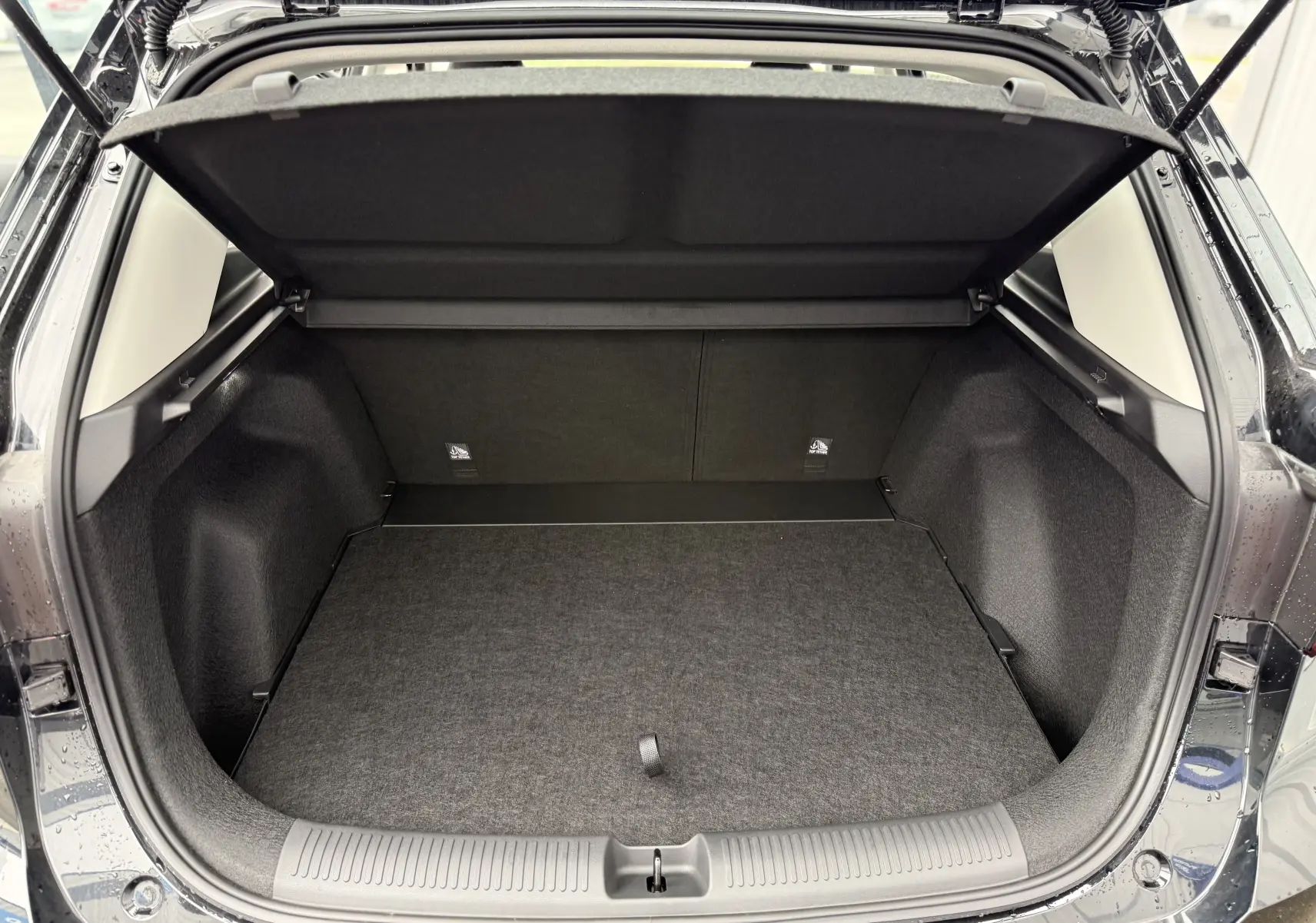 Coffre ouvert vu de l'arrière d'un MG ZS 1.5L Hybrid+ 2026 en Pebble Black Metal, espace de chargement vide et propre.