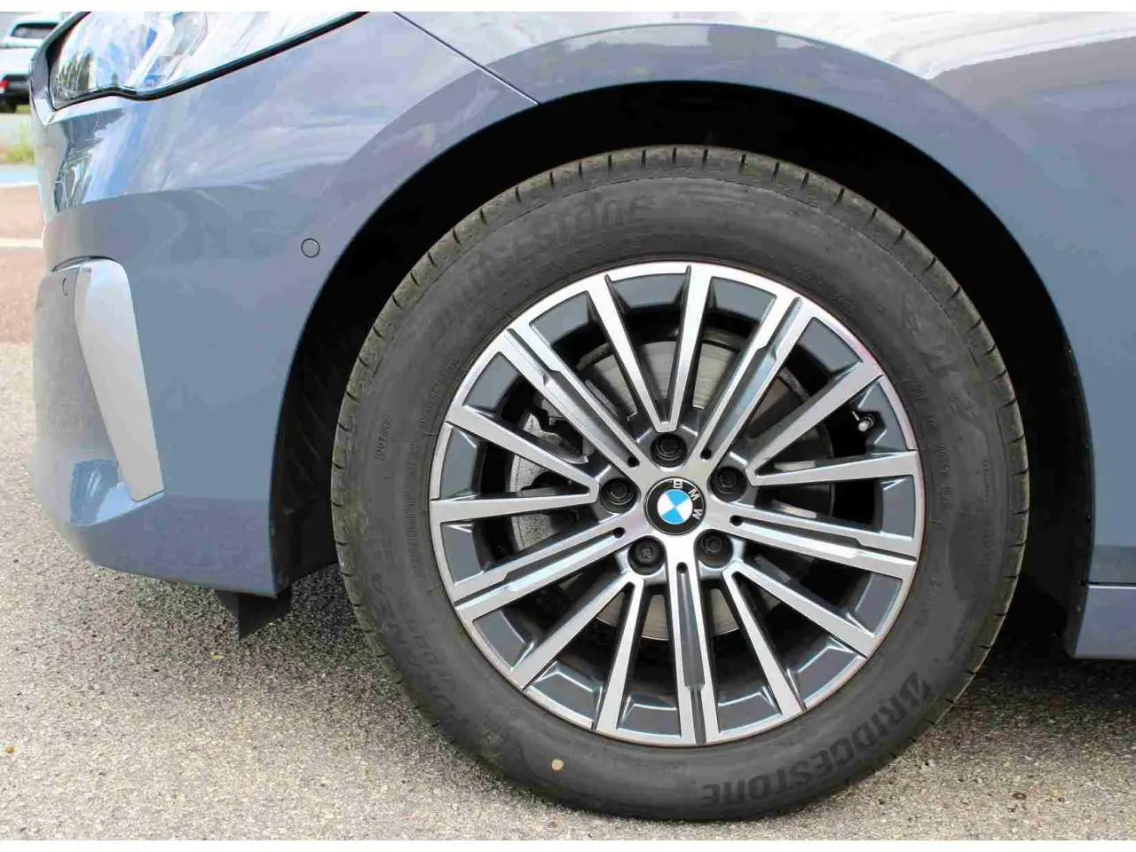 Gros plan sur la roue avant droite gris métallisé d'une BMW Série 2 Active Tourer avec jante alliage 17 pouces bicolore.