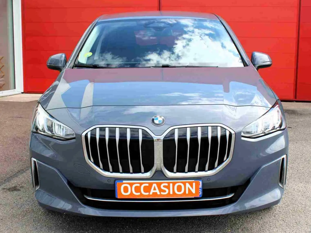 Vue avant d'une BMW Série 2 Active Tourer grise avec calandre chromée et plaque "OCCASION" orange.