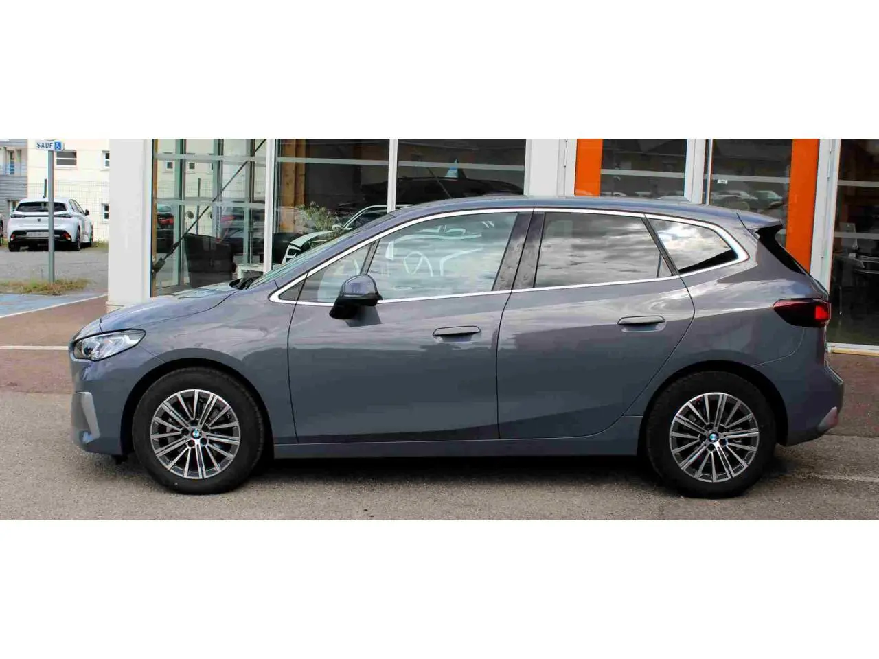 BMW Série 2 Active Tourer gris vue de profil côté gauche, avec jantes alliage 17 pouces et vitres teintées.