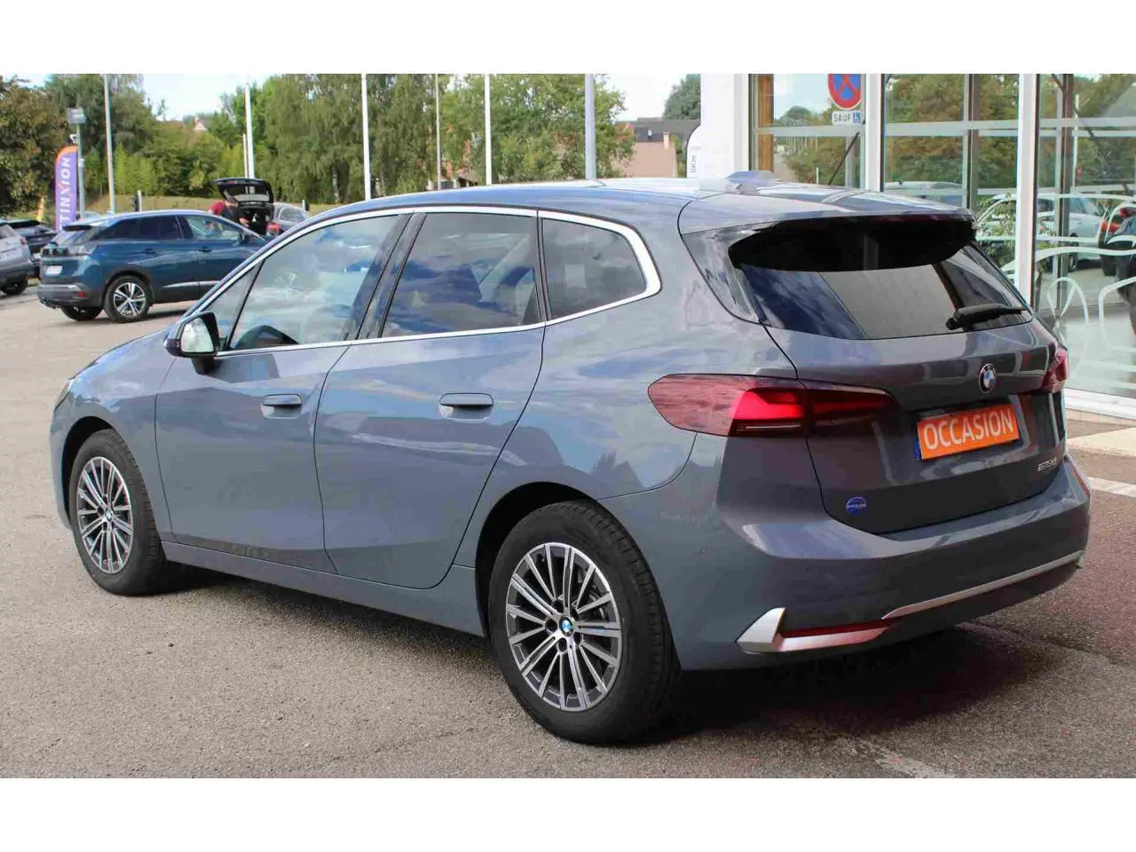 BMW Série 2 Active Tourer gris vue 3/4 arrière droit, feux arrière LED et jantes alliage 17 pouces visibles.