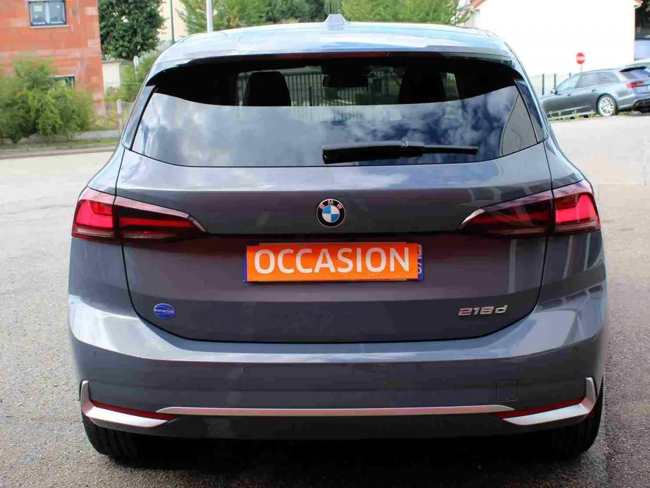 Vue arrière d’une BMW Série 2 Active Tourer grise 218d avec feux arrière LED et plaque orange « Occasion » visible.