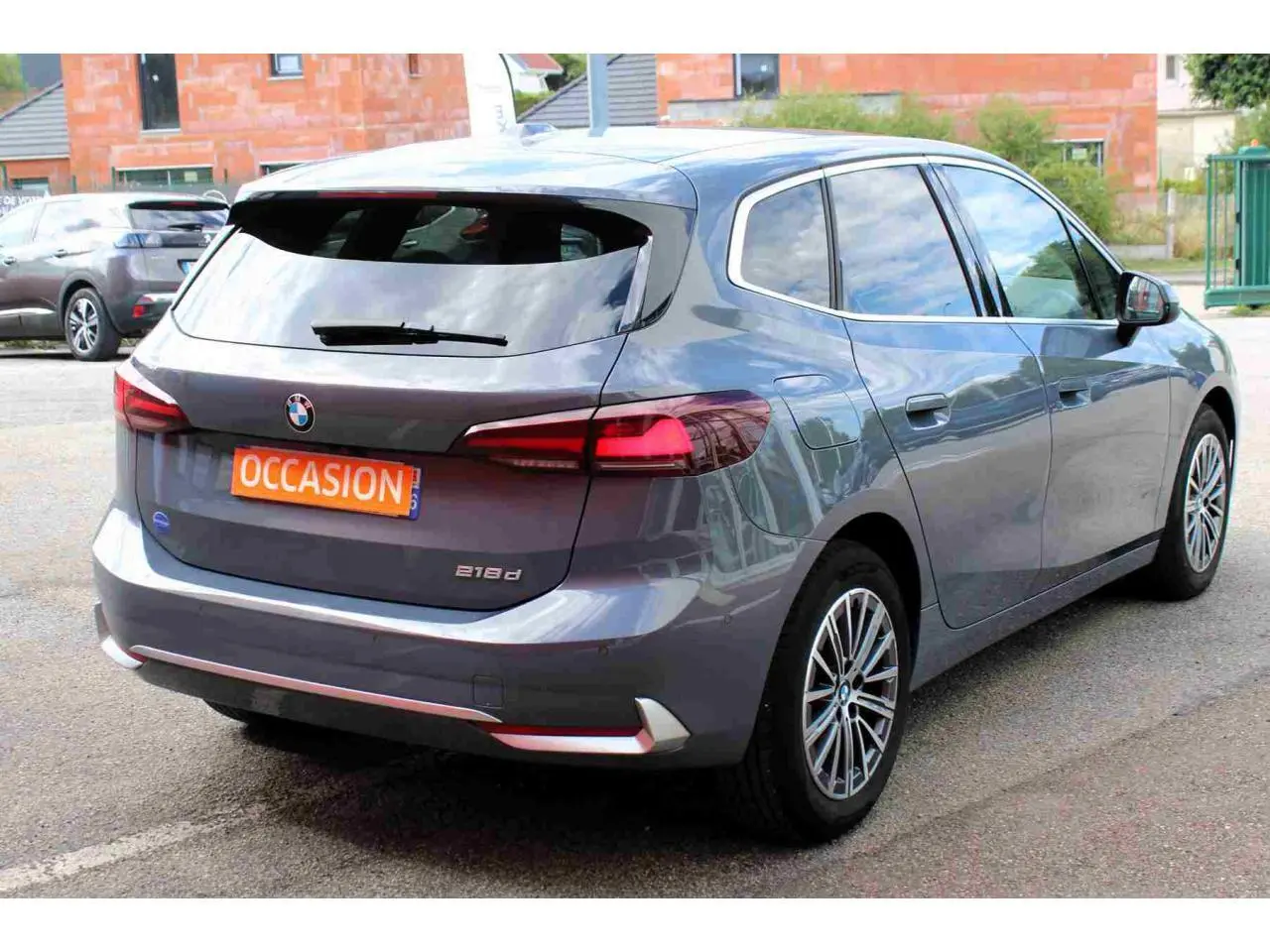 BMW Série 2 Active Tourer gris vue 3/4 arrière droit avec feux arrière LED et jantes alliage 17 pouces.