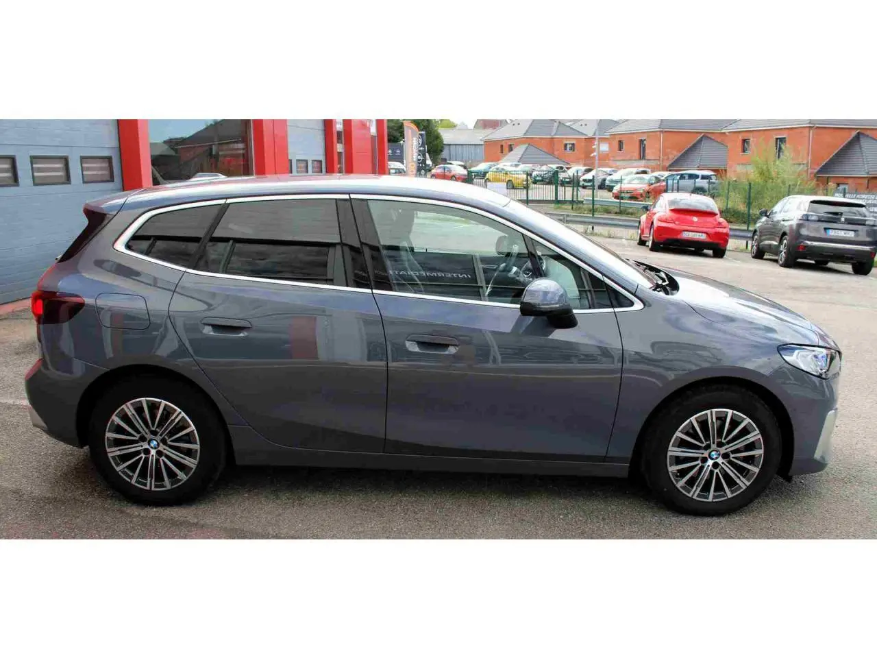 BMW Série 2 Active Tourer gris vue de profil côté gauche, avec jantes alliage 17 pouces et vitres teintées.
