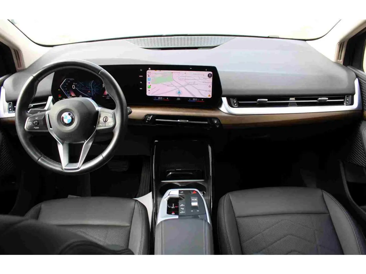 Vue intérieure avant du tableau de bord de la BMW Série 2 Active Tourer gris avec écran tactile incurvé et volant cuir multifonctions.