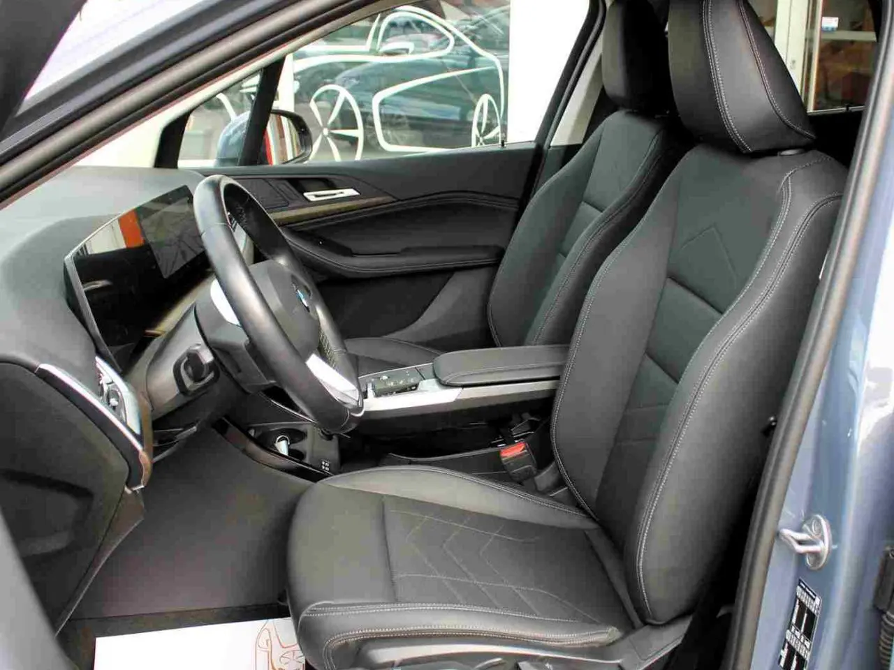 Intérieur avant droit d’une BMW Série 2 Active Tourer gris, sièges en similicuir noir avec coutures contrastées.